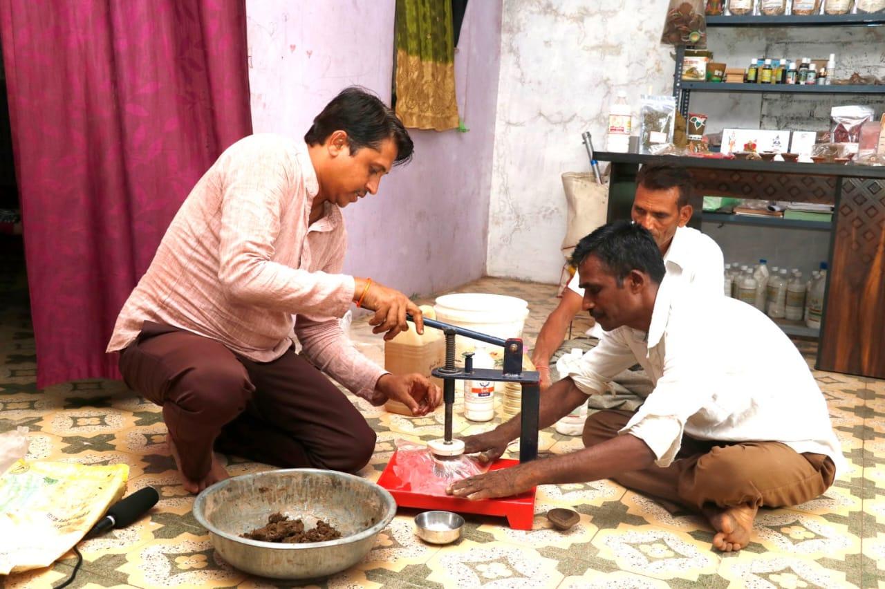 A trio of subsistence farmers making cow-based farming and subsistence items from cow dung